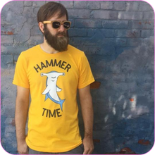 Load image into Gallery viewer, Bearded man wearing the Hammer Time Unisex Adult Tee and bamboo sunglasses, standing in front of a blue brick wall